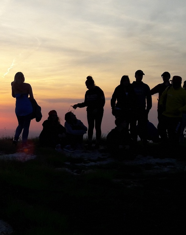 Gruppo di viaggiatori in controluce al tramonto